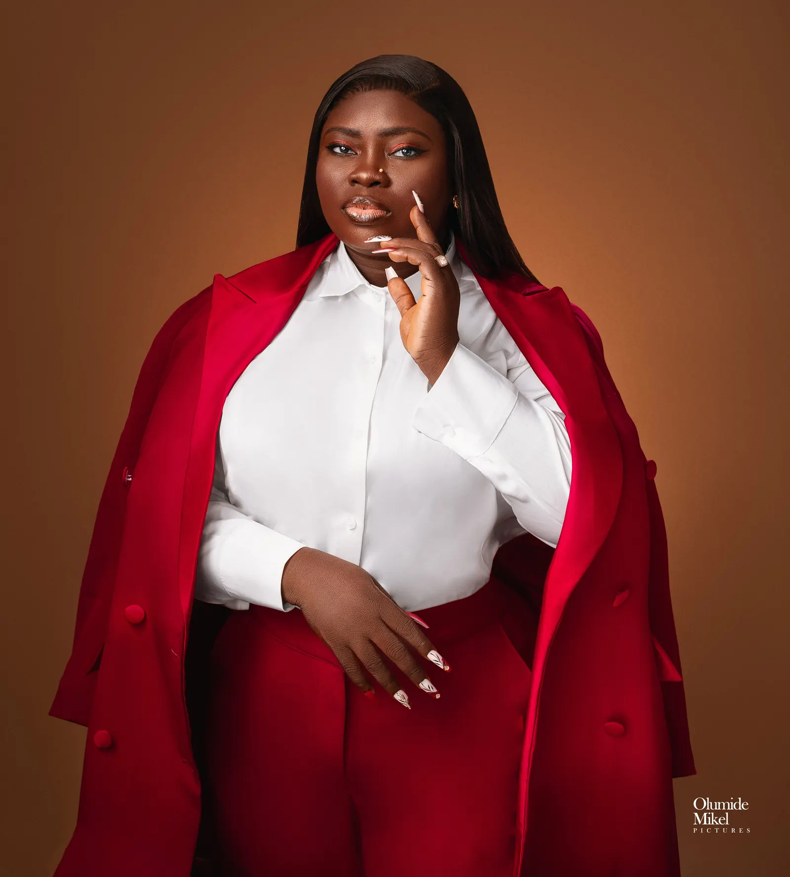 Blessing Bashorun in a red blazer and white shirt, hand raised to her chin